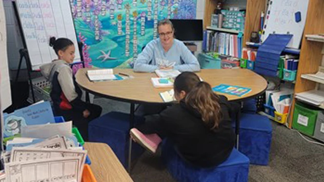 Students learning at a table. Students learning at a table.