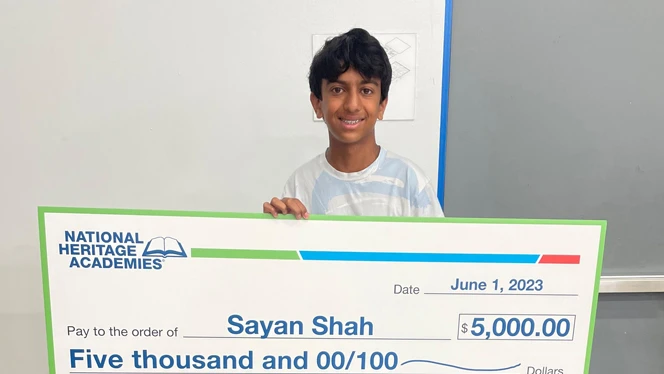 Sayan Shah holding his scholarship.