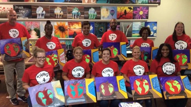Adults holding up their art. Adults holding up their art.