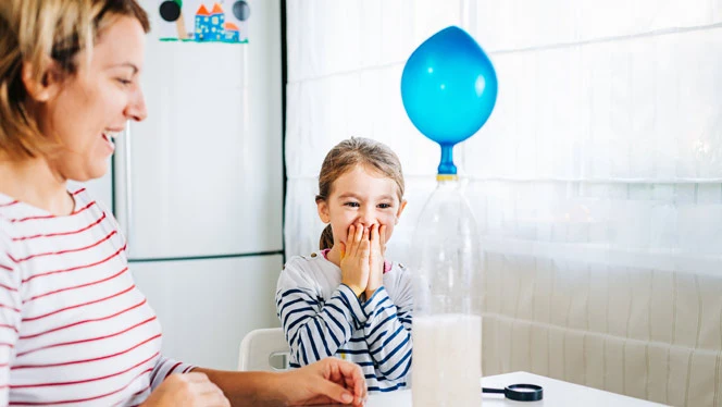 K-8 School in Lansing MI: Student and parenting doing balloon experiment.