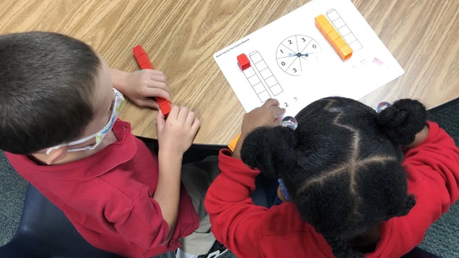 Children playing a game on a table. Children playing a game on a table.