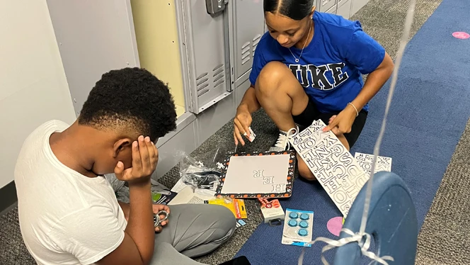 Two students decorating locker.