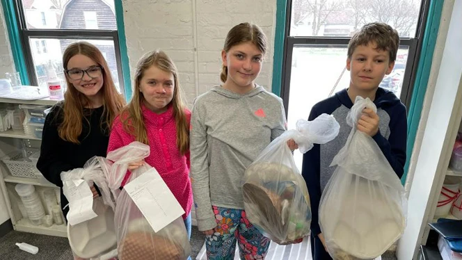 Students carrying full trash bags. Students carrying full trash bags.