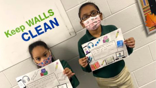 Children holding up their artwork. Children holding up their artwork.