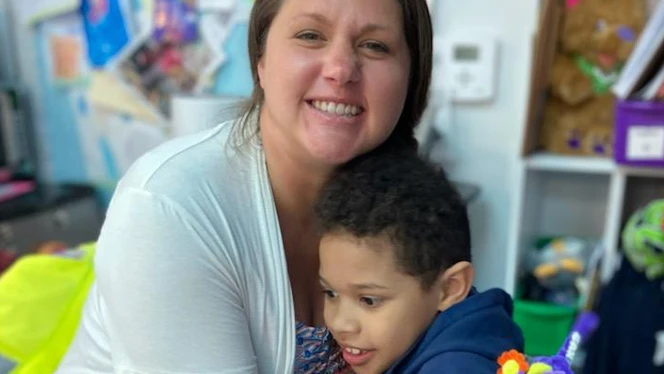 Meagan Moorhouse hugging student.