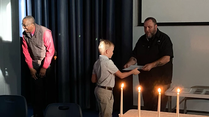 Man handing boy a piece of paper. Man handing boy a piece of paper.