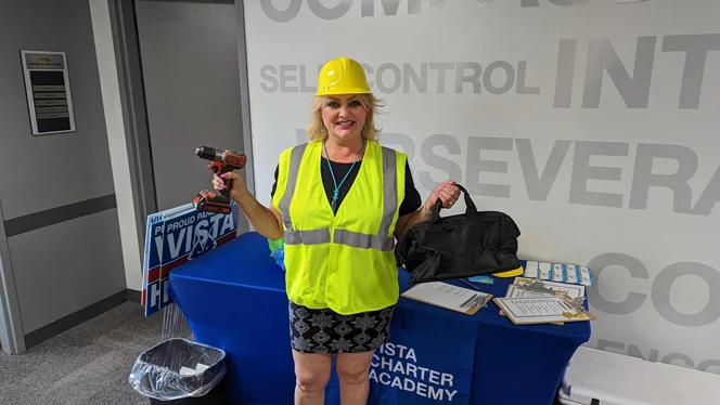 A woman holding a power drill and holding a tool bag. A woman holding a power drill and holding a tool bag.