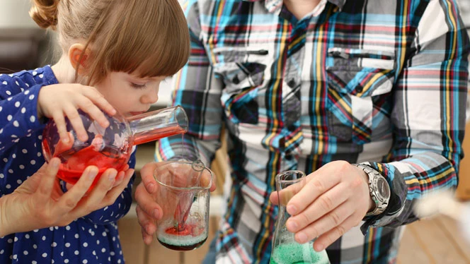 K-8 School in Lansing MI: Student and parenting doing food coloring experiment.