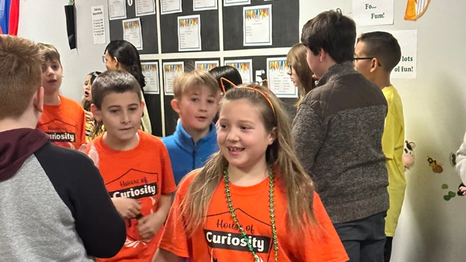 Student wearing house "Curiosity" shirt.