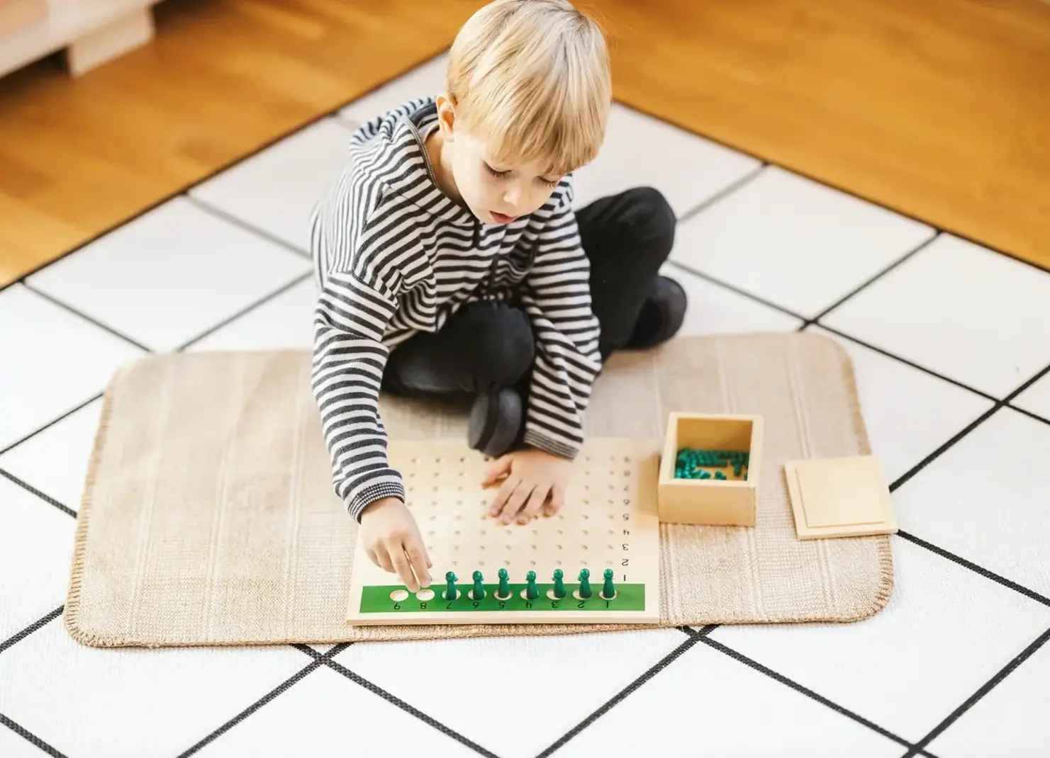 Boy sitting on the floor playing with a math game