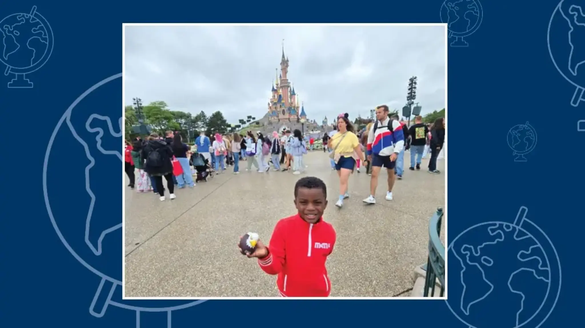 a boy holding a donut in front of a castle