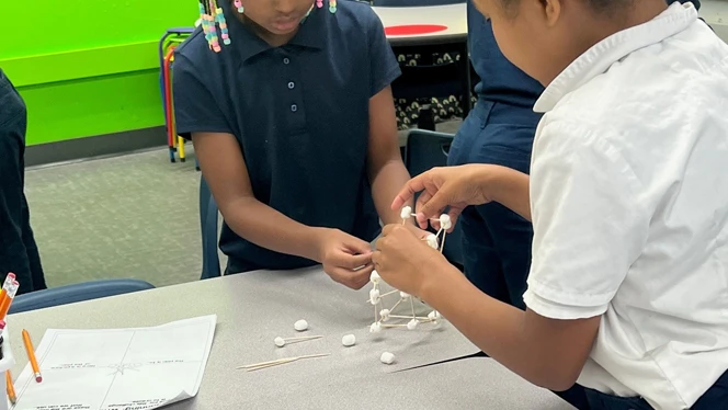 Students building tall structure.