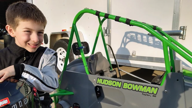Hudson sits proudly by his quarter midget car. Hudson sits proudly by his quarter midget car.