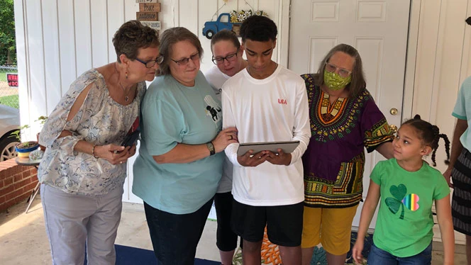 Anthony Byrd and others gathered around a tablet Anthony Byrd and others gathered around a tablet