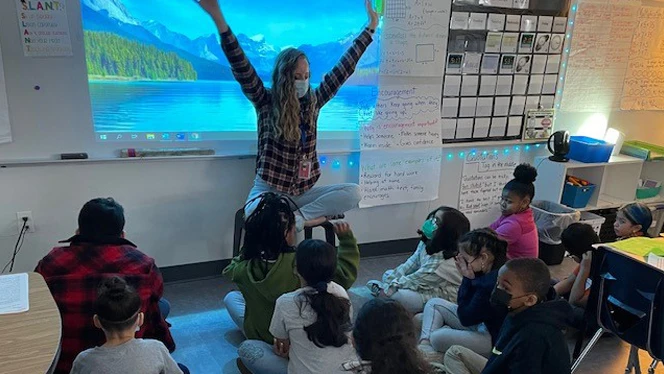 Teacher leading students in controlled breathing.
