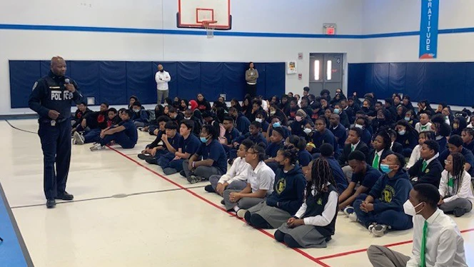 A police officer addresses group of students