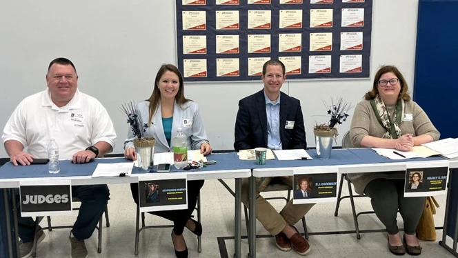 Spelling bee judges sitting at a table.