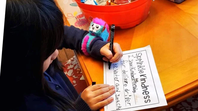 Child at a table writing Child at a table writing