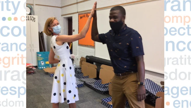 Sally Girouard high fives a teacher