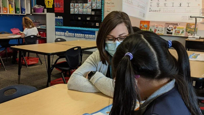 Student and teacher at a table. Student and teacher at a table.