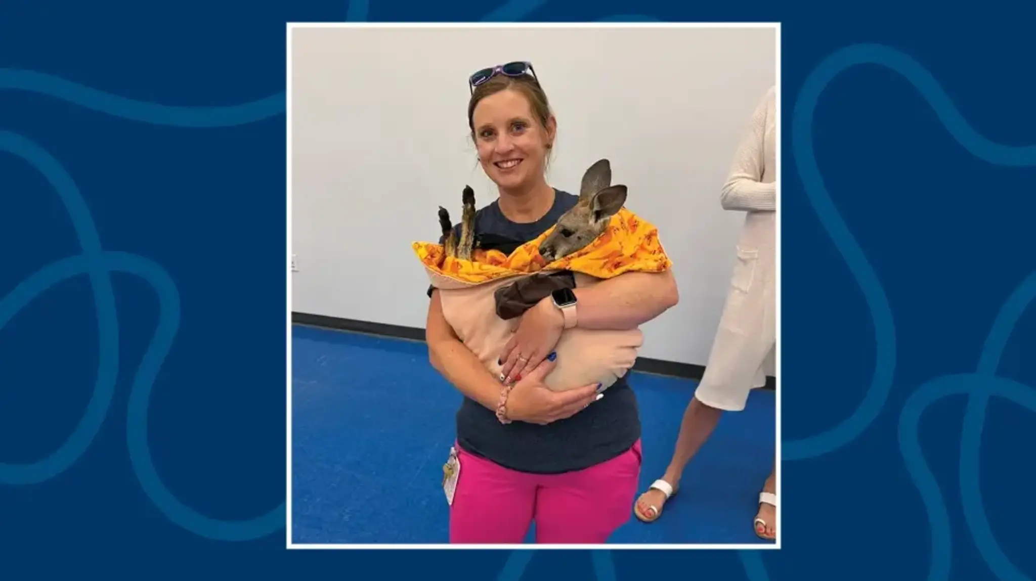 a woman holding a kangaroo