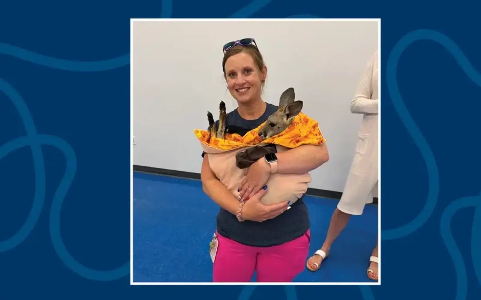 a woman holding a kangaroo
