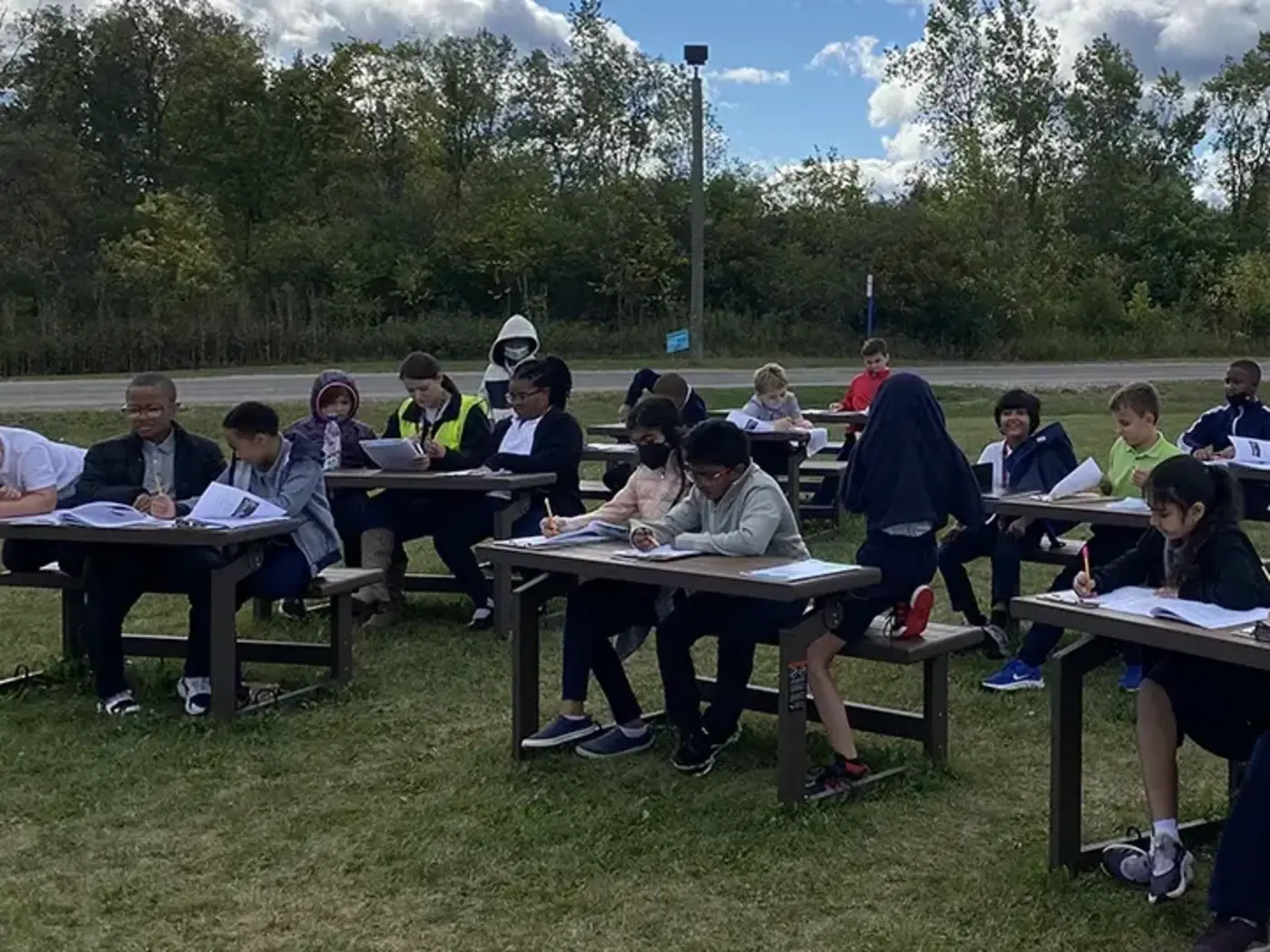 Students sitting at desks outdoors
