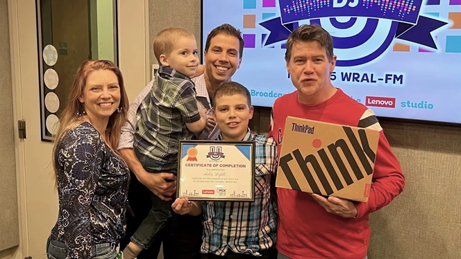 Aiden Defillo and his family pose with WRAL DJ Doug Miller