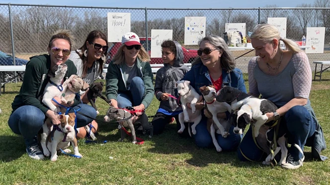 Adults holding puppies.