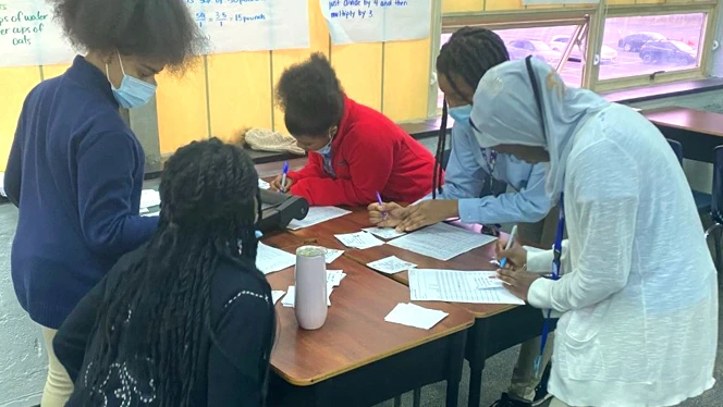 students writing at a table