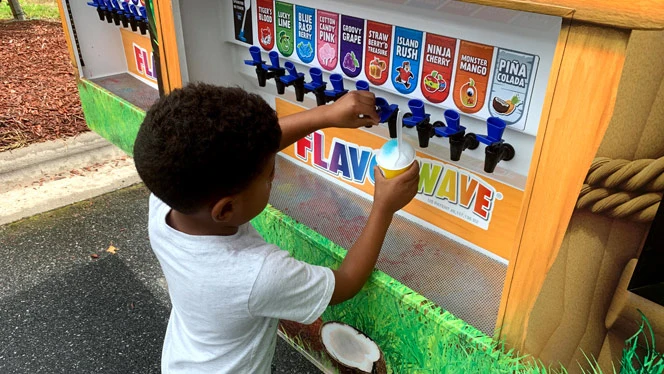 A child flavoring their snow cone. A child flavoring their snow cone.