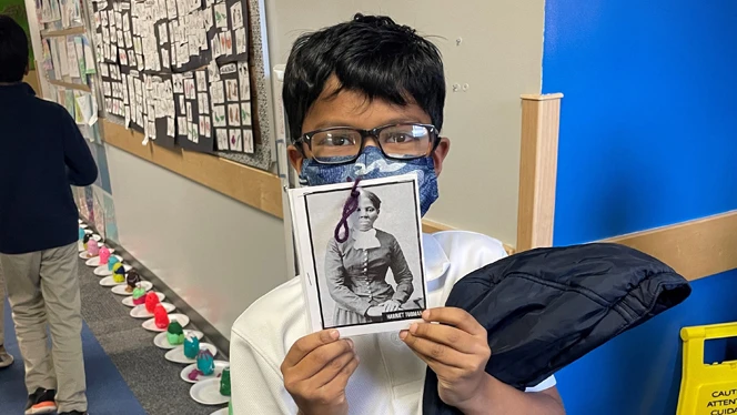 Student holding up photo of significant black history figure.