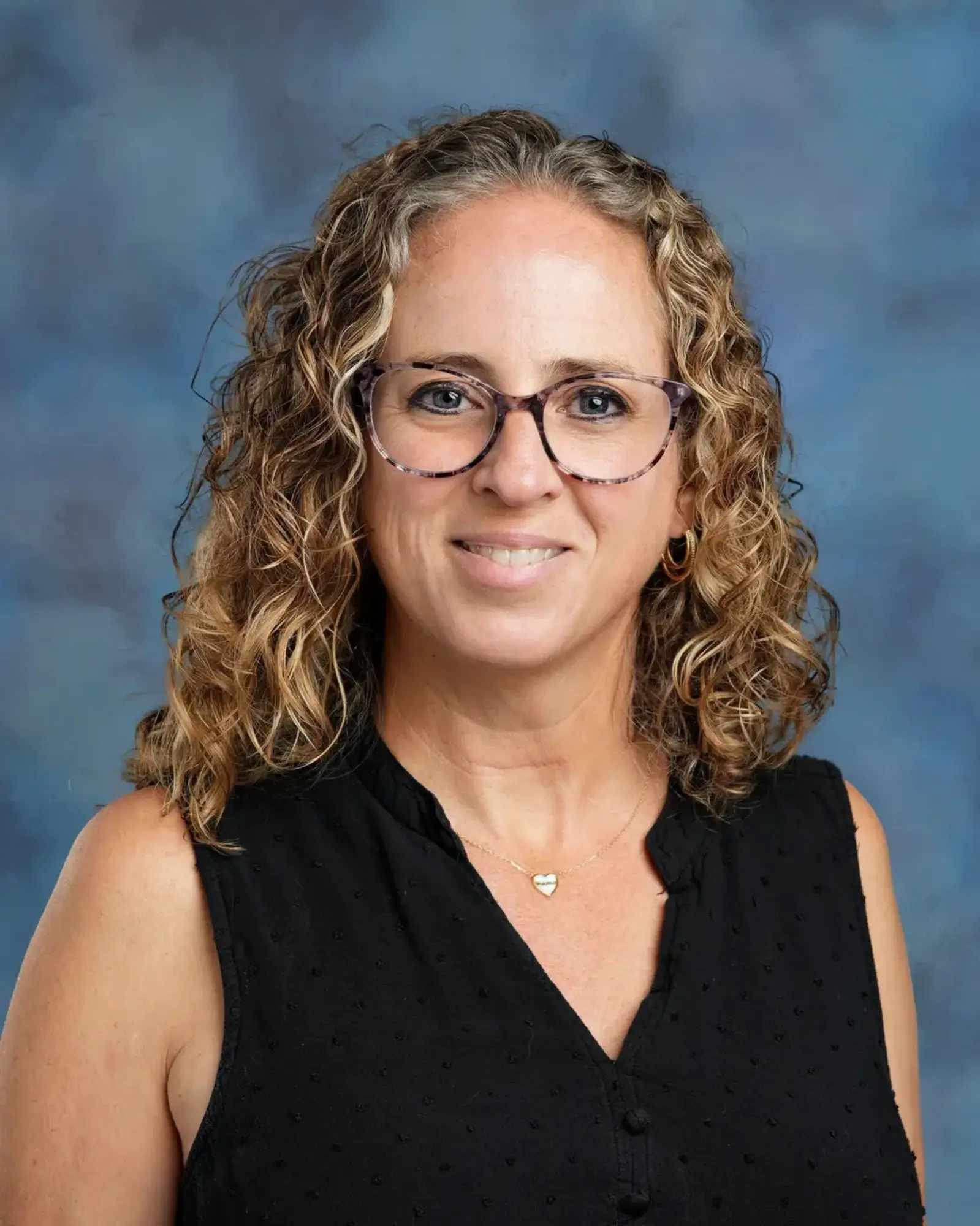 a woman with curly hair wearing glasses