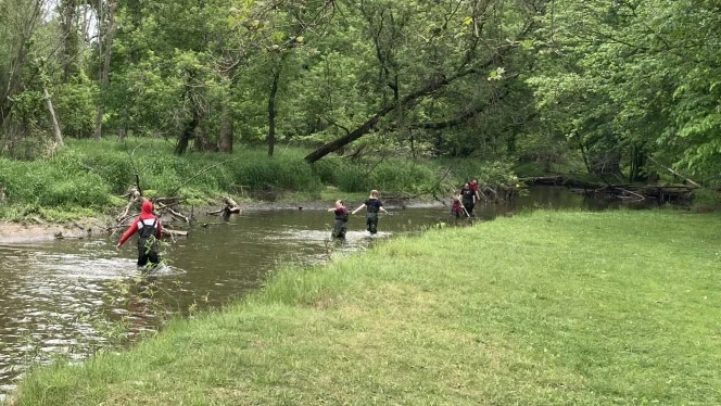 Students trudging their way through the river. Students trudging their way through the river.
