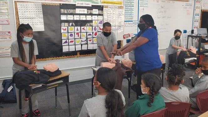 Students practicing CPR on a dummy. Students practicing CPR on a dummy.