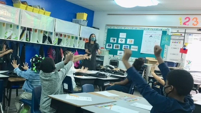 Student raising their hands to be called on.