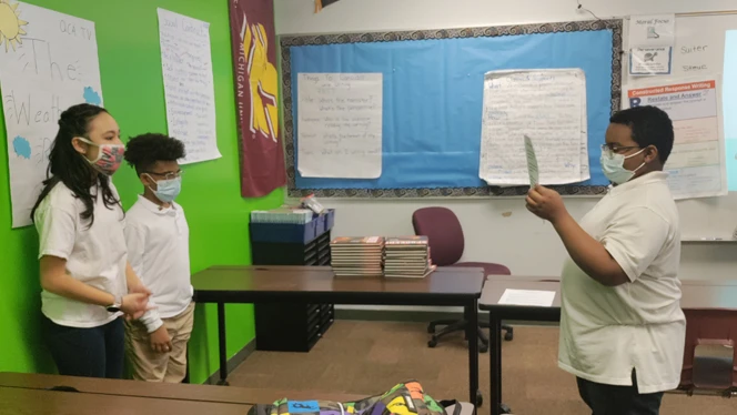 students reading off their paper teleprompter
