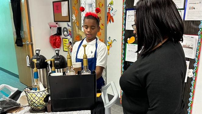 Student serving coffee at Daily Grind.