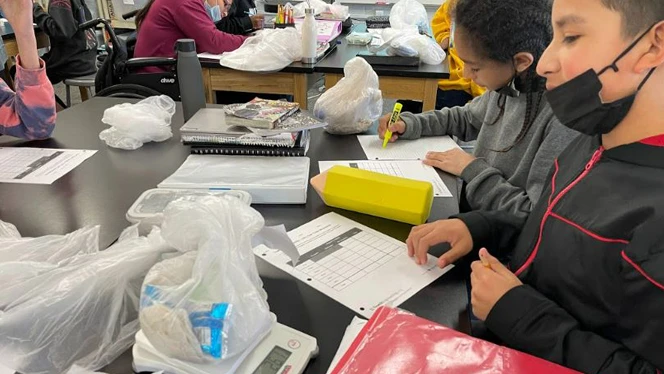 Students weighing their trash bags.
