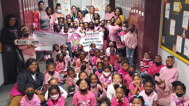 A class smiling wearing wearing pink shirts. A class smiling wearing wearing pink shirts.