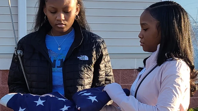 Students holding the United States flag. Students holding the United States flag.