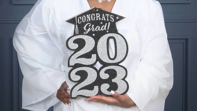 Camajah Moore-Harris holding a congratulations sign.