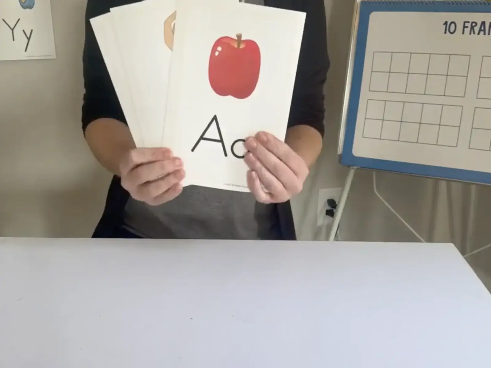 Teacher holding letter cards.