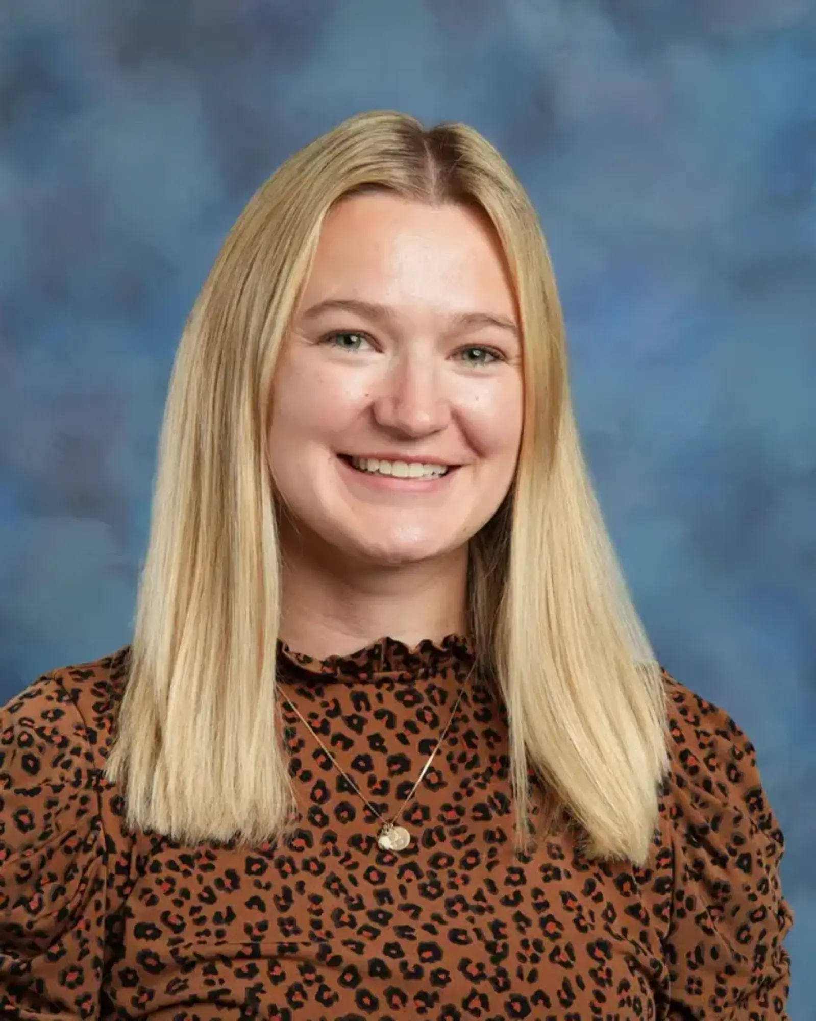 a woman with blonde hair wearing a leopard print shirt