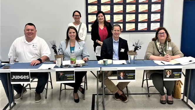 Spelling bee judges sitting at a table.