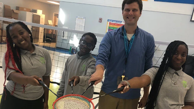 K-8 School in Milwaukee: Students and Anderson pose with badminton equipment.
