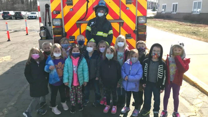 Class standing with a firefighter. Class standing with a firefighter.
