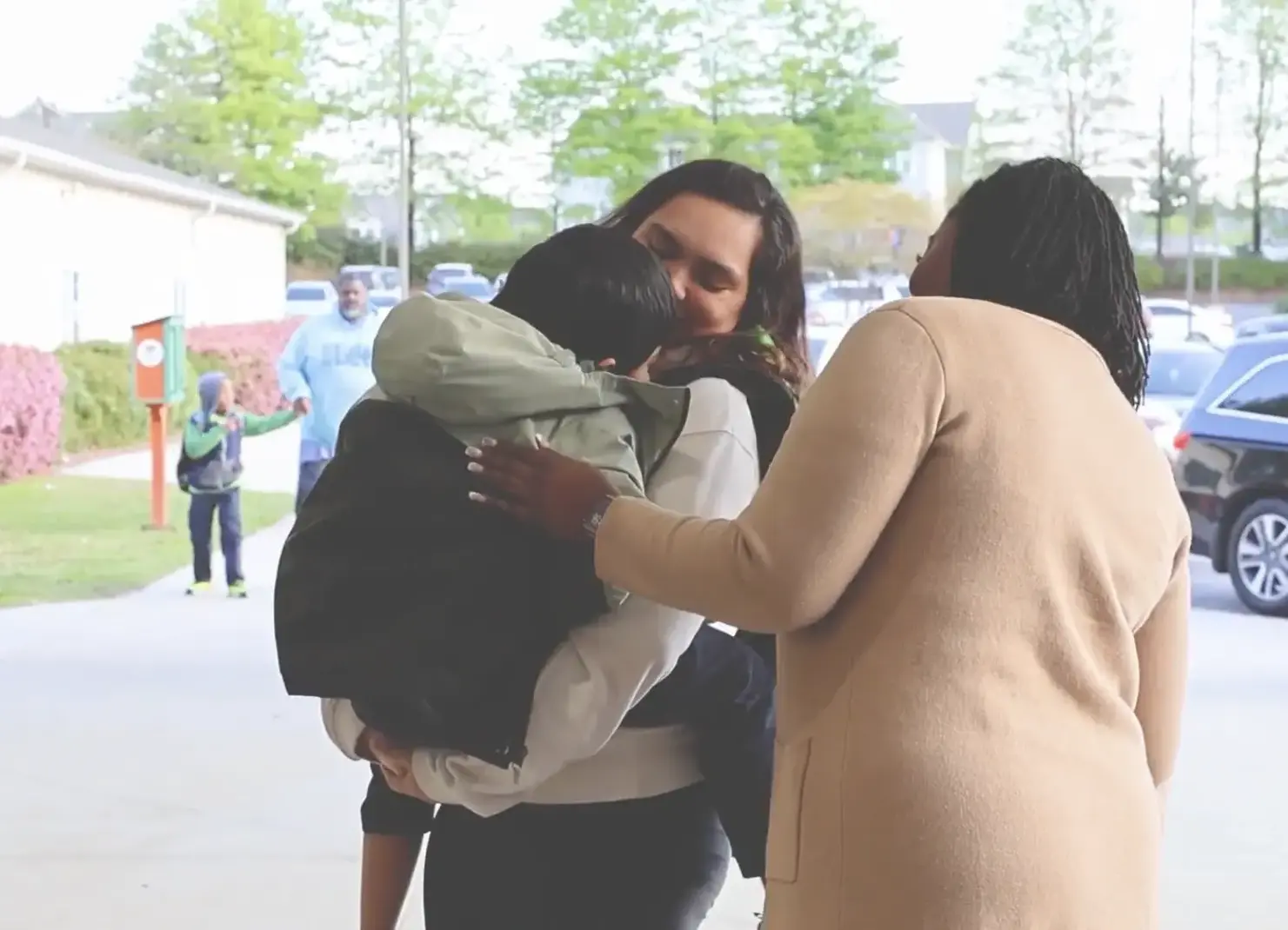 Mom walking into school carrying a child