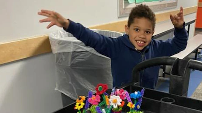 Child smiling while working with arts and crafts.