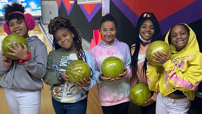 Children holding bowling balls.
